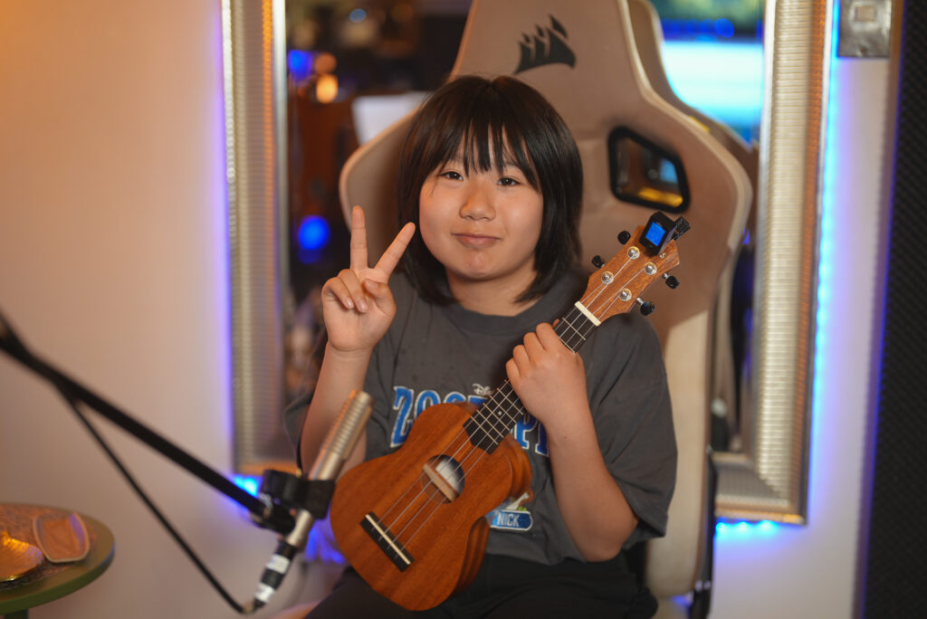 レッスンでギターを弾く小学3年生の生徒