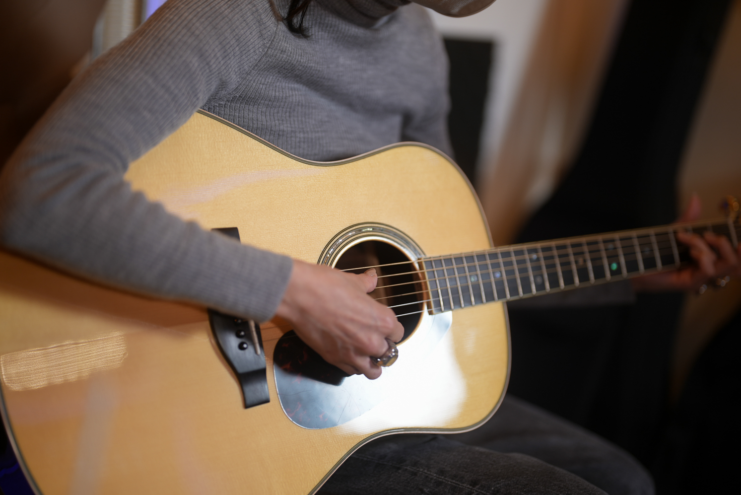 レッスンでギターを弾く女性生徒