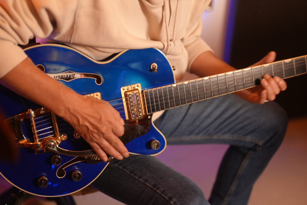 レッスンでギターを弾く男性生徒