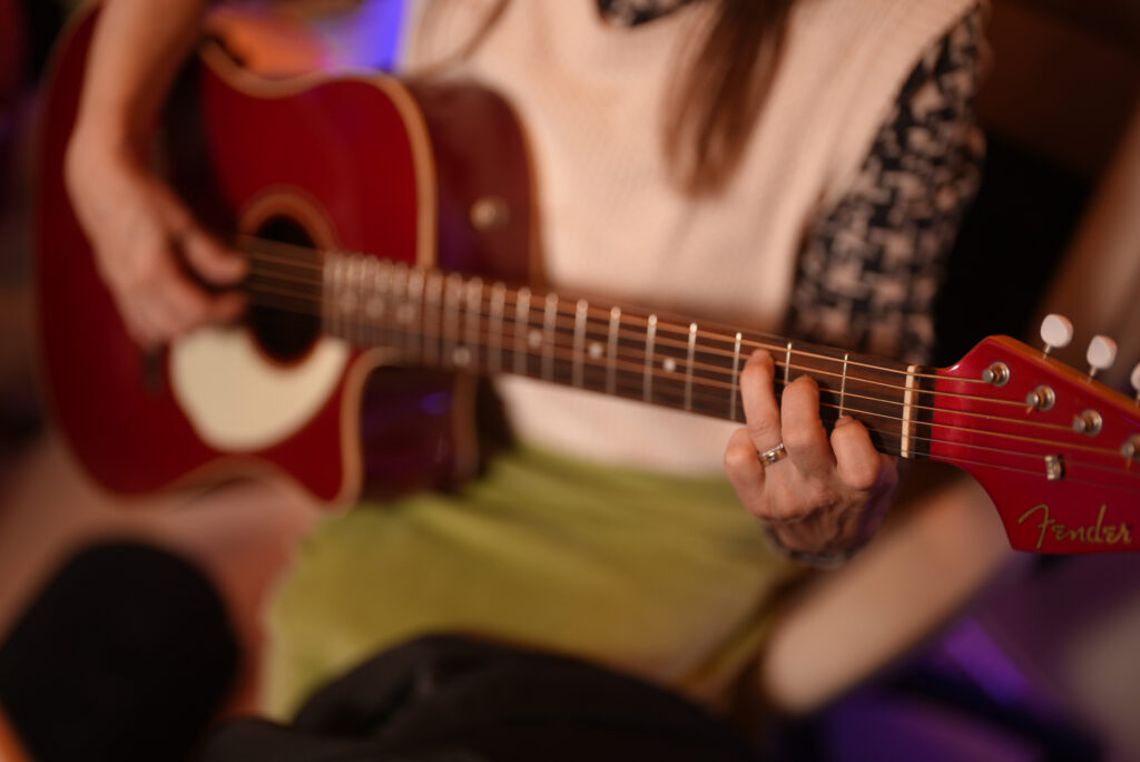 レッスンでギターを弾く女性生徒