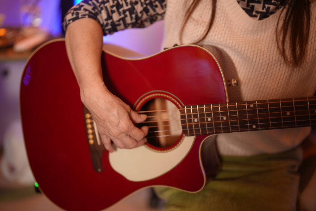 レッスンでギターを弾く女性生徒