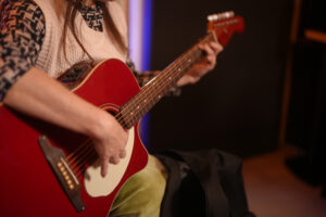 レッスンでギターを弾く女性生徒