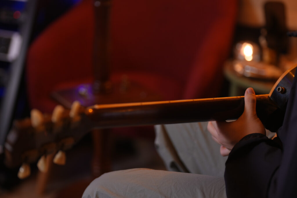 レッスンでギターを弾く男性生徒