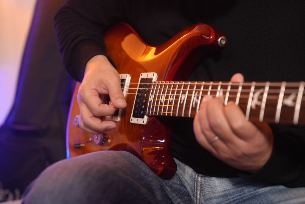 レッスンでギターを弾く男性生徒