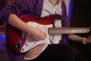 レッスンでギターを弾く女性生徒