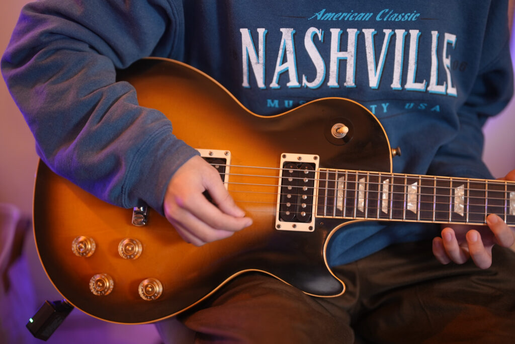 レッスンでギターを弾く男性生徒