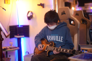 レッスンでギターを弾く男性生徒