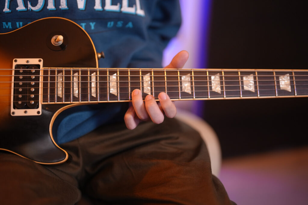 レッスンでギターを弾く男性生徒