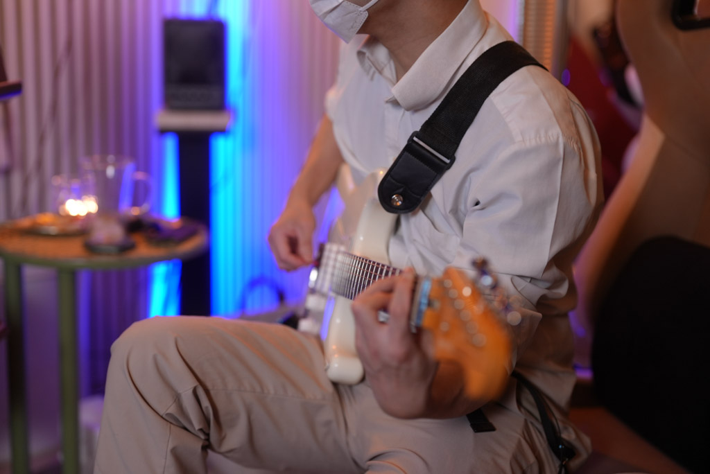 レッスンでギターを弾く男性生徒