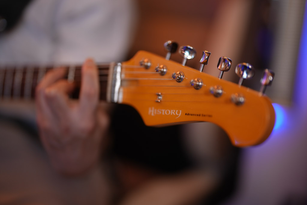 レッスンでギターを弾く男性生徒