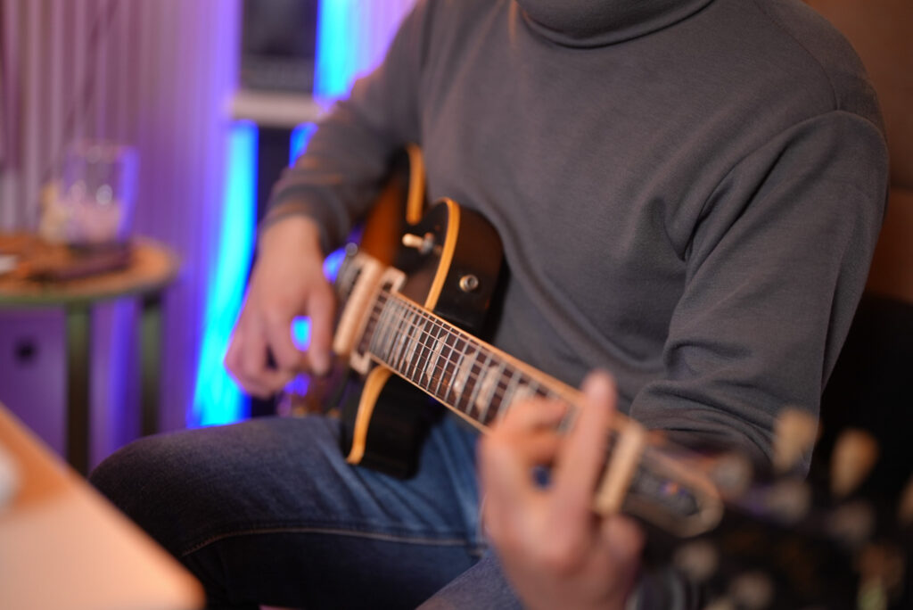 レッスンでギターを弾く男性生徒