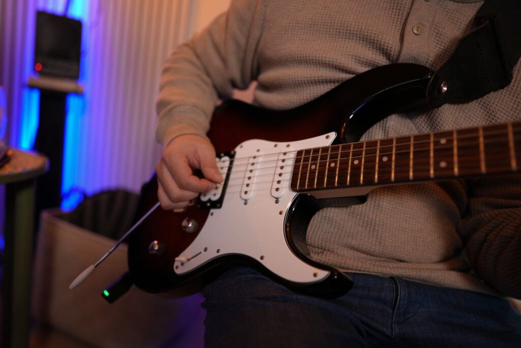 レッスンでギターを弾く男性生徒