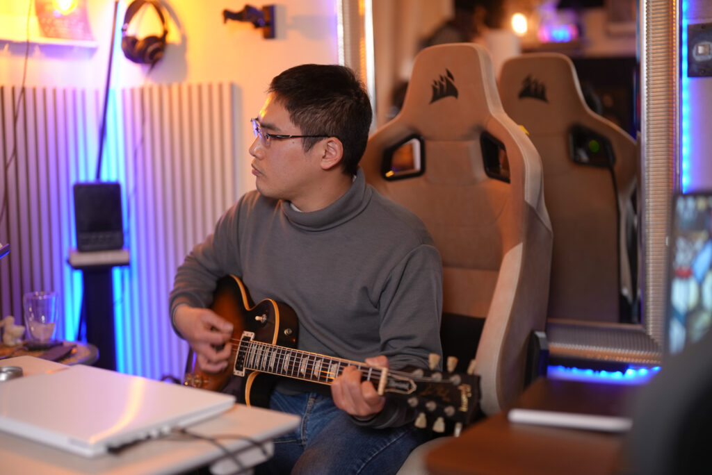 レッスンでギターを弾く男性生徒
