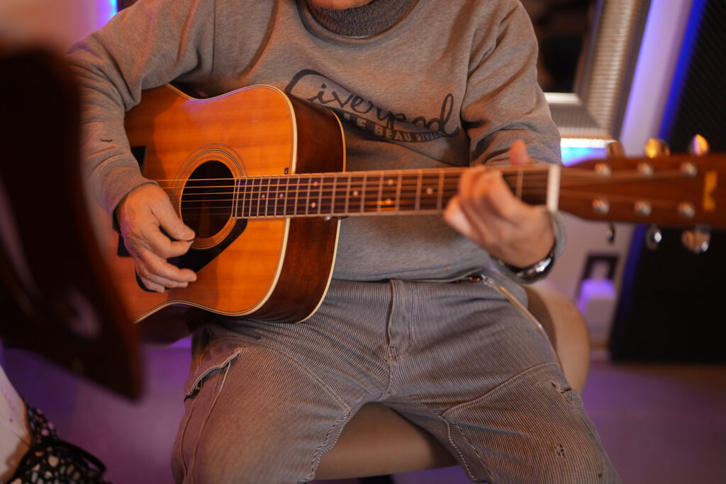 レッスンでギターを弾く男性生徒3