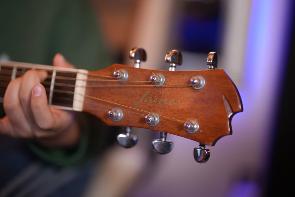 レッスンでギターを弾く中学生、女性生徒