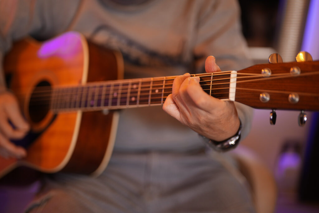 レッスンでギターを弾く男性生徒2