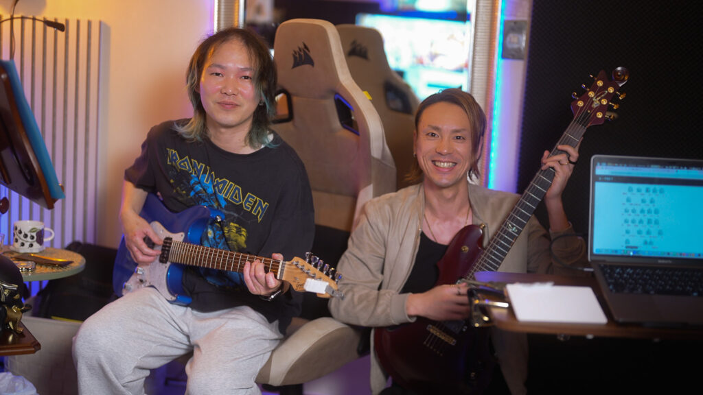 レッスンでギターを弾く男性生徒と講師、小俣太治の写真