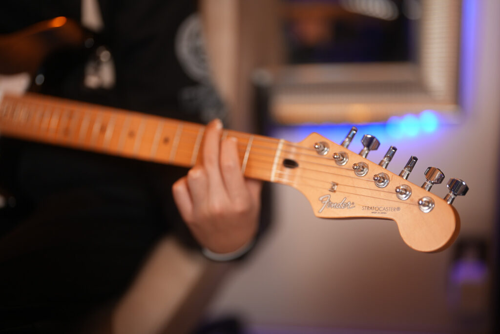 レッスンでギターを弾く男性、中学生の生徒2