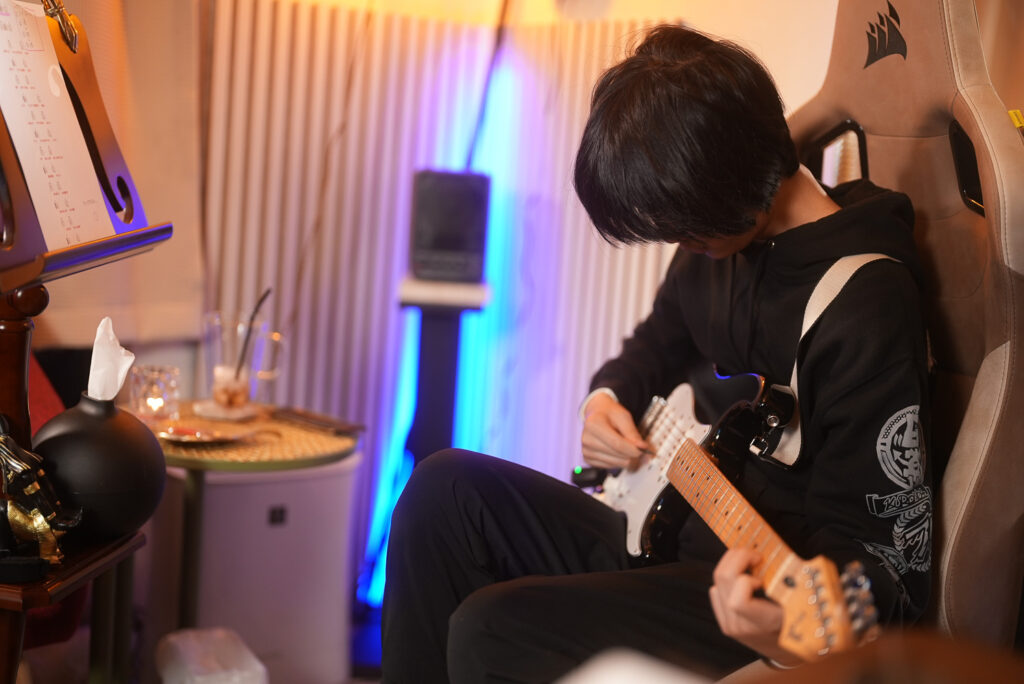 レッスンでギターを弾く男性、中学生の生徒3