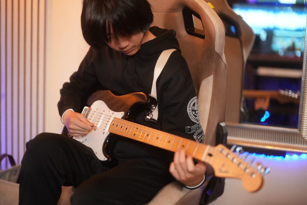 レッスンでギターを弾く男性、中学生の生徒