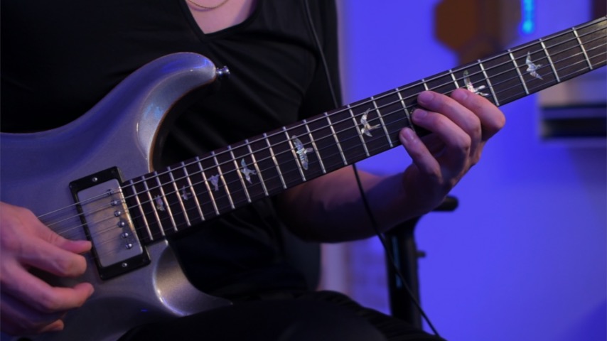 ギターを講師が弾いている画像