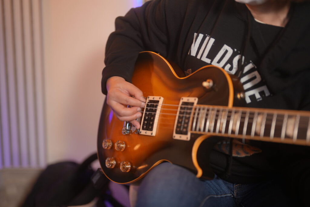 レッスンでギターを演奏する女性生徒