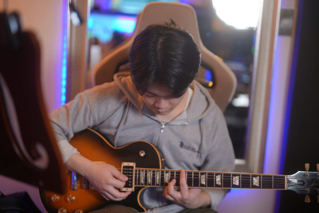レッスンでギターを弾く男性生徒