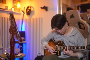 レッスンでギターを弾く男性生徒