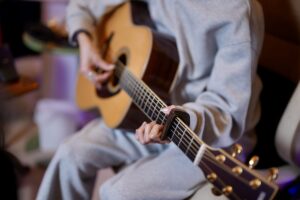 レッスンでギターを演奏する女性生徒
