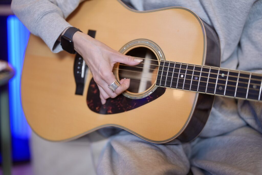 レッスンでギターを演奏する女性生徒