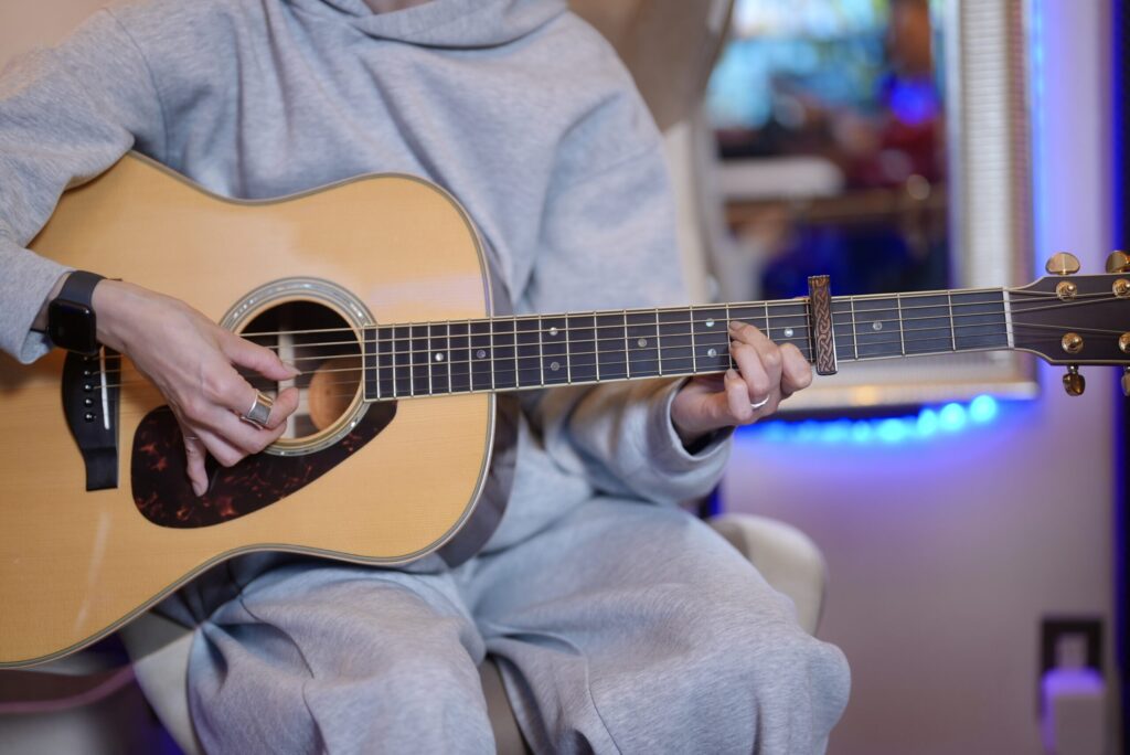 レッスンでギターを演奏する女性生徒