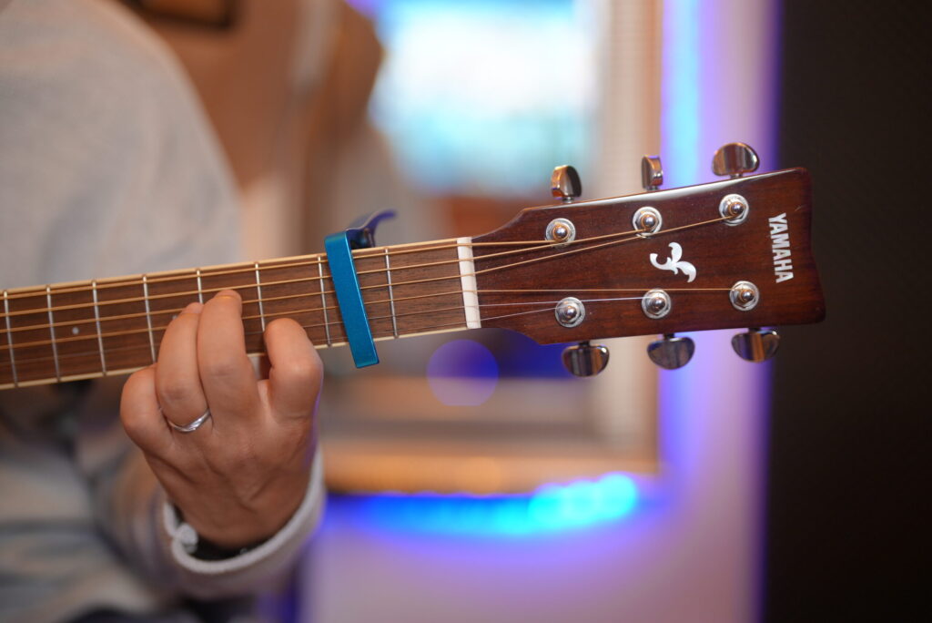 レッスンでギターを弾く男性生徒と講師