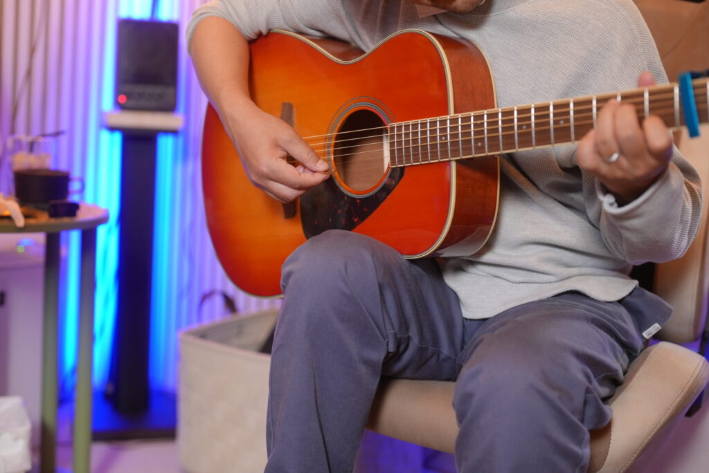 レッスンでギターを弾く男性生徒と講師