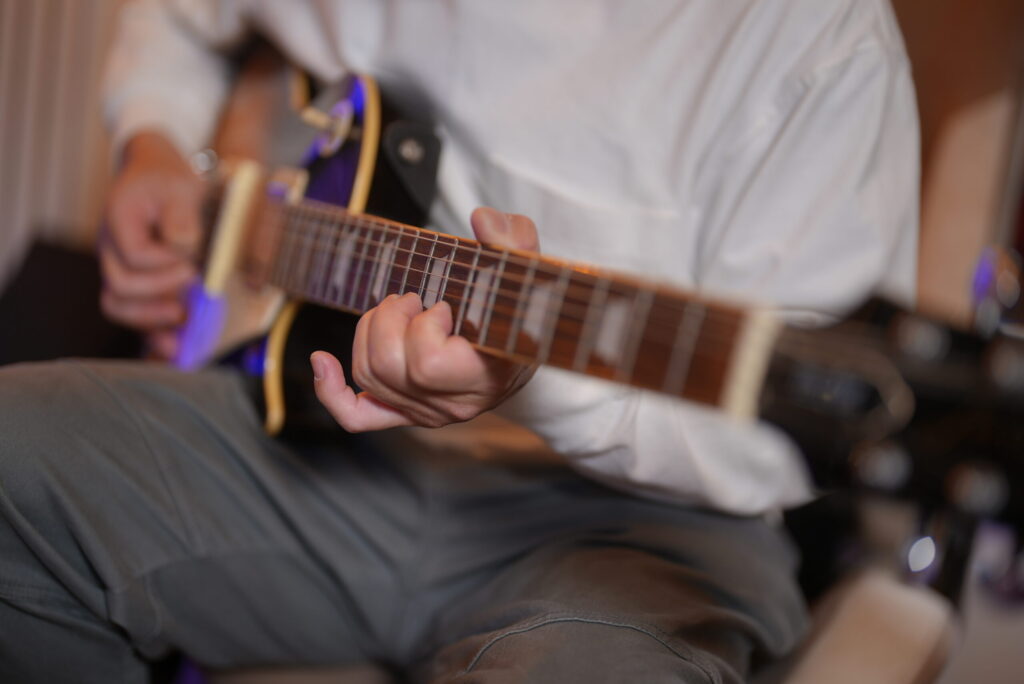 レッスンでギターを弾く男性生徒