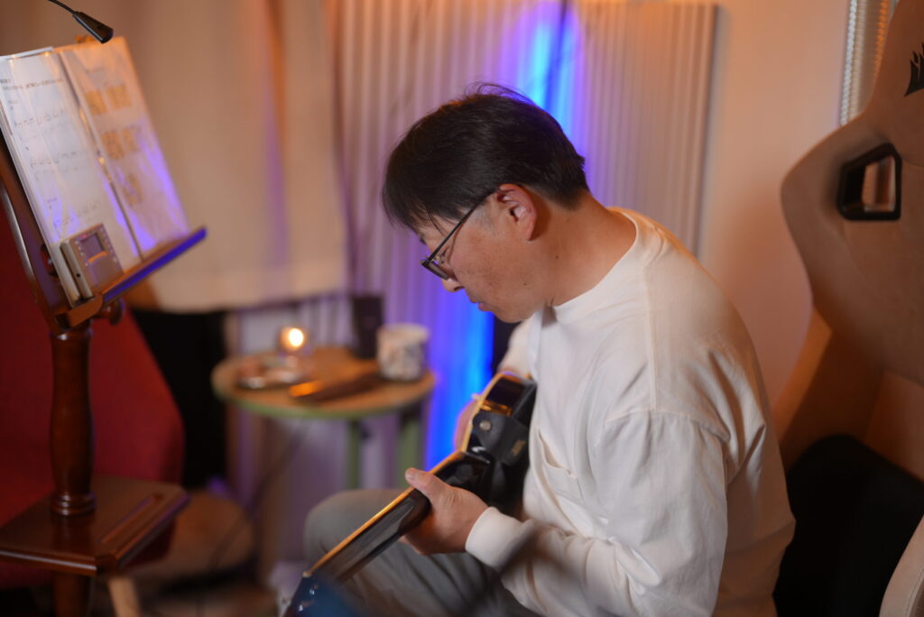 レッスンでギターを弾く男性生徒