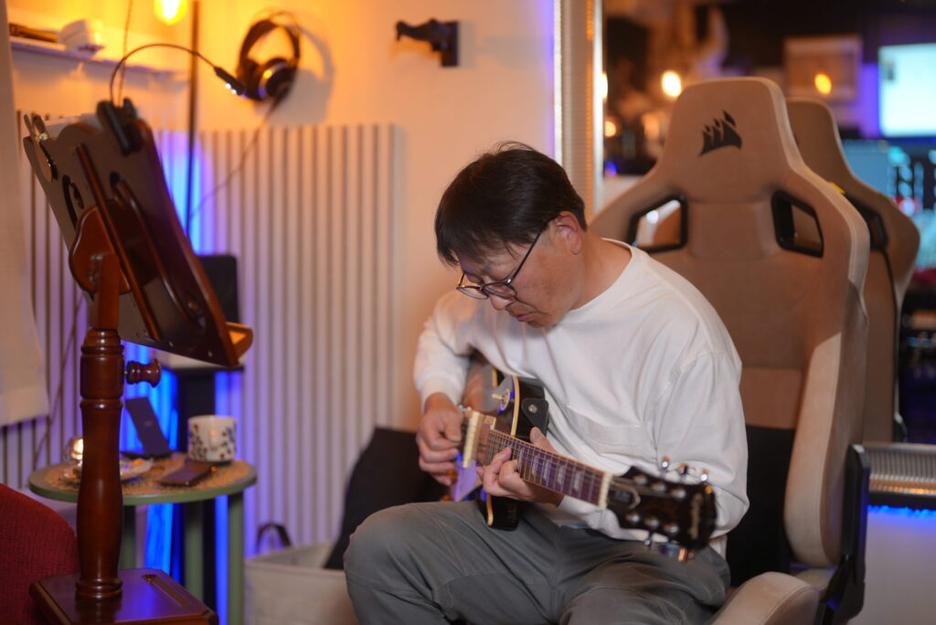 レッスンでギターを弾く男性生徒
