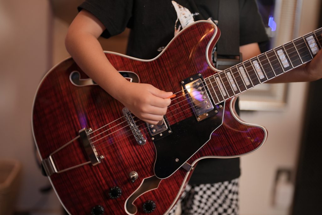 レッスンでギターを弾く小学2年生の生徒
